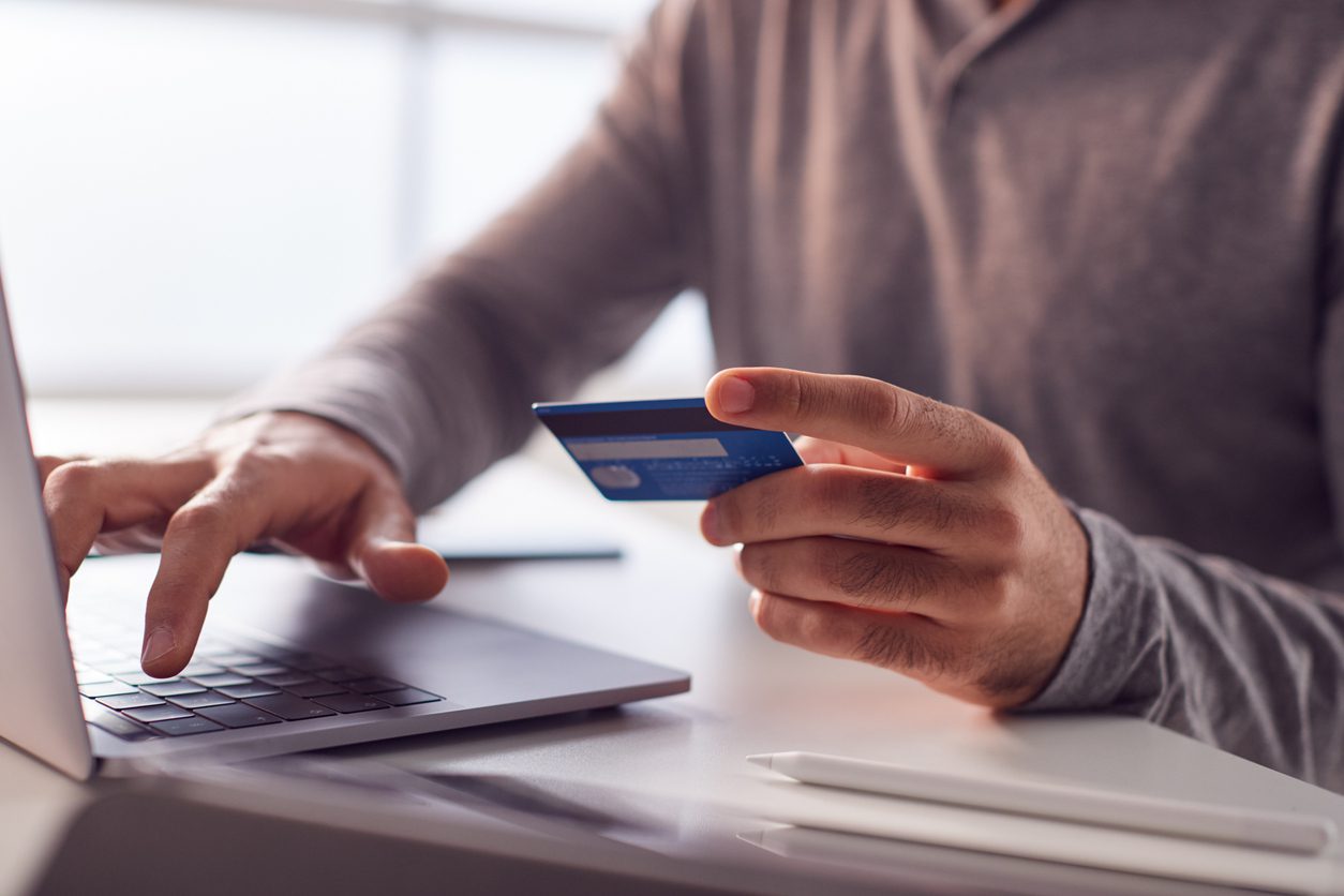 close-up-of-businessman-working-late-on-laptop-at-desk-making-online-payment-with-credit-card
