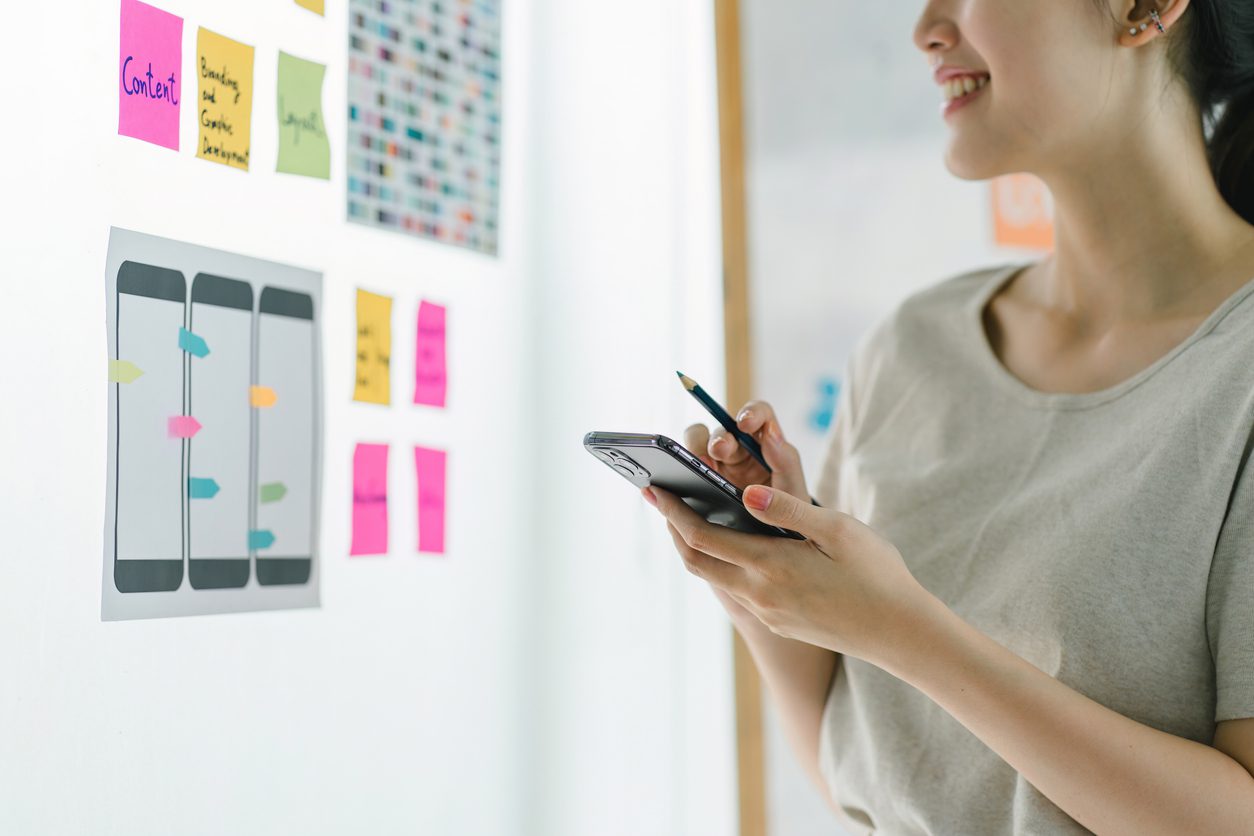 creative-ux-designer-brainstorming-designing-screens-for-mobile-responsive-website-development-with-ui-ux-developing-wireframe-sketch-layout-design-mockup-on-smartphone-screen