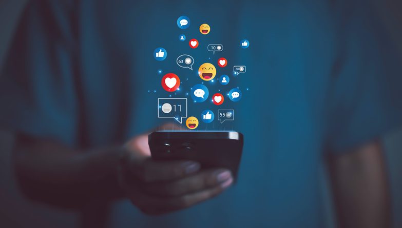 person-using-smartphone-with-social-media-icons-likes-hearts-and-emojis-floating-symbolizing-online-communication-digital-marketing-social-network-engagement-and-modern-lifestyle