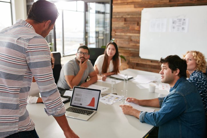 young-man-giving-business-presentation-to-colleagues